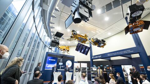 Hessische Landesregierung verabschiedet Raumfahrtstrategie des Landes bei EUMETSAT Bild der Pressekonferenz mit Satelliten-Modellen an der Decke.
